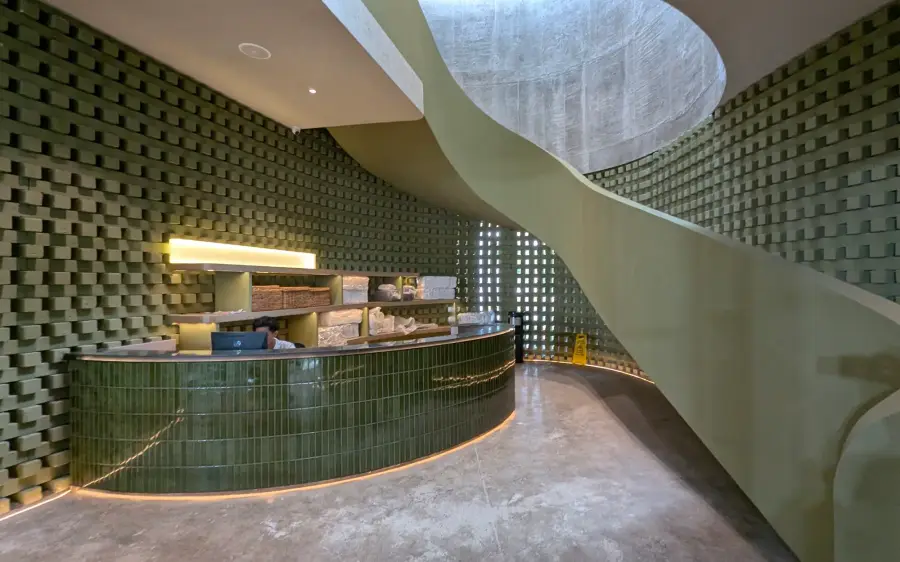 Green-tiled bar beneath a spiral staircase