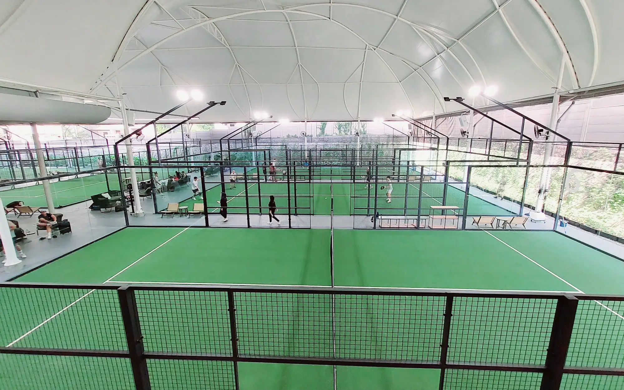 Six green courts under the white tensile roof at Padel Pro Signature
